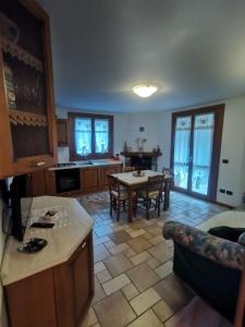 una cucina e un soggiorno con tavolo e sedie di APPARTAMENTO CORTAIOLO HOUSE a Vione