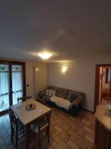 a living room with a couch and a table at APPARTAMENTO CORTAIOLO HOUSE in Vione