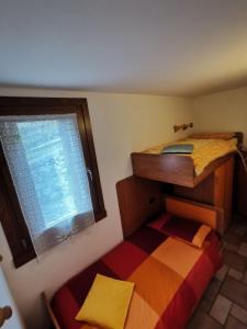 a bedroom with two bunk beds and a window at APPARTAMENTO CORTAIOLO HOUSE in Vione