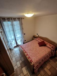 a bedroom with a bed in a room with a window at APPARTAMENTO CORTAIOLO HOUSE in Vione