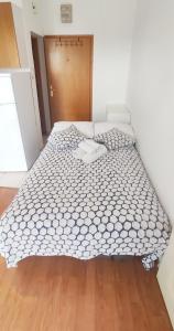 uma cama grande num quarto com piso em madeira em Jana apartman em Crikvenica