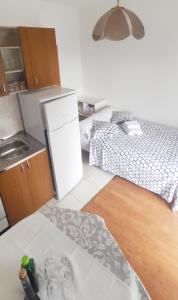 uma pequena cozinha com um frigorífico e uma cama em Jana apartman em Crikvenica