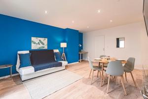 a bedroom with a blue wall and a table and chairs at Plancy Beds St-Quentin in Saint-Quentin
