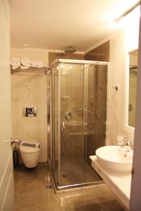 a bathroom with a shower and a toilet and a sink at Achilles Hotel in Methoni