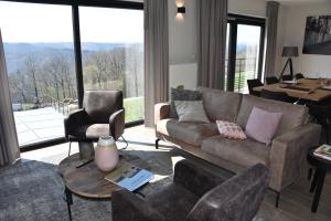 sala de estar con sofá, mesa y sillas en Rochehaut, Les Semoiselles, Villa Charlotte, en Bouillon