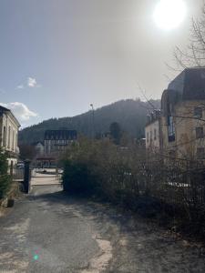 a dirt road with buildings and the sun in the sky at La Parisette in La Bourboule