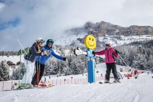 a group of three people standing on a ski slope at Garni Flurida in Badia
