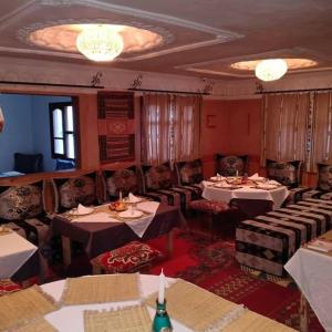 Hôtel Restaurant La Gazelle De Dades في Akhendachou nʼAït Ouffi: مطعم فيه طاولات وكراسي في الغرفة