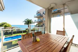 a wooden table on a balcony with a view of the ocean at Hauzify I Apartaments Panoramic in Miami Platja