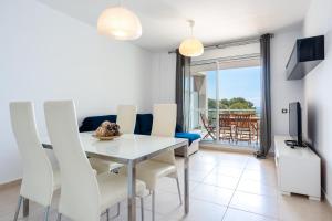 a dining room with a table and chairs and a television at Hauzify I Apartaments Panoramic in Miami Platja +33 photos