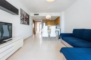 a living room with a blue couch and a table at Hauzify I Apartaments Panoramic in Miami Platja