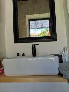 lavabo blanco en el baño con espejo en La Alberca 2 Casa para parejas con piscina, en Tenzuela