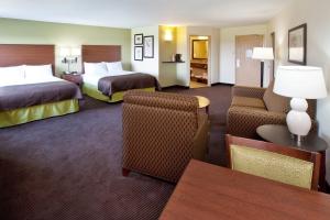 Habitación de hotel con 2 camas y sofá en AmericInn by Wyndham Osage, en Osage
