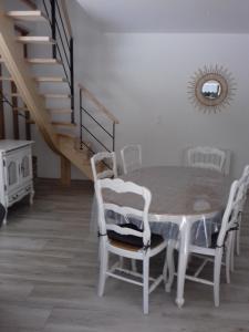 a dining room with a table and chairs and stairs at Gite Le Ranch 6 pers in Tirepied