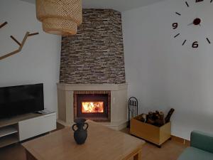 a living room with a fireplace and a tv at "La Villa de Iker" con Piscina, Barbacoa y a 10 mint de Puy du Fou in Argés