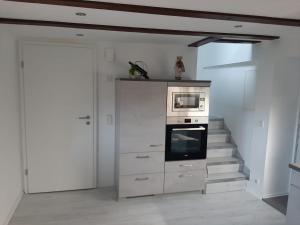 a white room with a staircase with a tv and an oven at Ferienhaus Schmalkalden in Schmalkalden