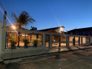a building with a fence and a palm tree at SOLAR DA BRAN Mosqueiro - Pará in Belém