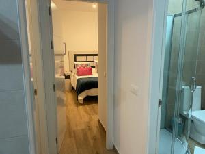 ein Zimmer mit einem Schlafzimmer mit einem Bett und einem Spiegel in der Unterkunft Ático Laan en Setenil de las Bodegas in Setenil de las Bodegas