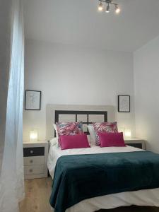 a bedroom with a large bed with two red pillows at Ático Laan en Setenil de las Bodegas in Setenil