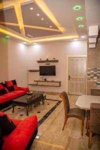 uma sala de estar com um sofá vermelho e uma mesa em Lotus housing for furnished apartments em Gérasa