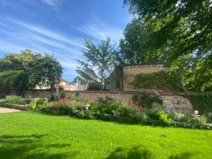 a garden with a stone wall and flowers at La Villa Alma Colmar in Colmar