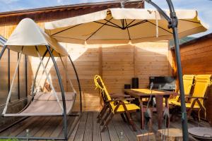 an umbrella on a deck with a table and chairs at Lampenhof in Brunico