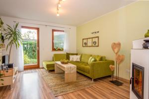 ein Wohnzimmer mit einer grünen Couch und einem Kamin in der Unterkunft Lampenhof in Bruneck