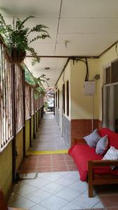 un couloir avec un lit rouge dans un bâtiment dans l'établissement Cabinas Coco Alegre, à Coco