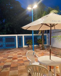 a table and chairs with an umbrella on a patio at SOLAR DA BRAN Mosqueiro - Pará in Belém