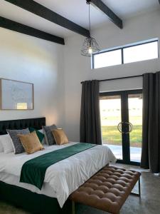 een slaapkamer met een groot bed en een groot raam bij Merino Stal Guest Farm in Ermelo