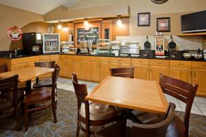 a restaurant with two wooden tables and a kitchen at AmericInn by Wyndham Princeton MN in Princeton