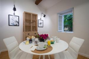 ein weißes Esszimmer mit einem weißen Tisch und weißen Stühlen in der Unterkunft Casa de Santa Rita in São Roque