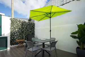 einen Tisch und Stühle mit gelbem Regenschirm auf einer Terrasse in der Unterkunft Casa de Santa Rita in São Roque