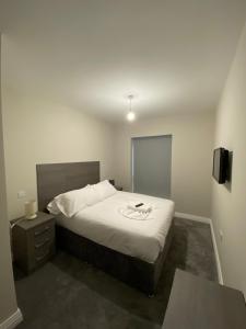 a bedroom with a bed and a table and a television at Buckingham Apartments in High Wycombe