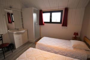 - une chambre avec un lit, un lavabo et un miroir dans l'établissement Hôtel Le Tuc de l'Etang, à Boutx