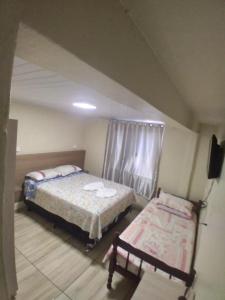 um quarto com duas camas e uma televisão em JH santos em Chapecó