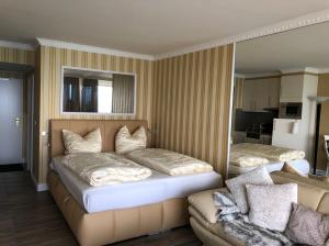 a bedroom with two beds and a couch at Tiffanys Ferienapartments in der Privatresidenz des Plaza Premium Hotel Timmendorfer Strand in Timmendorfer Strand +42 photos