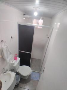 een badkamer met een wit toilet en een wastafel bij JH santos in Chapecó