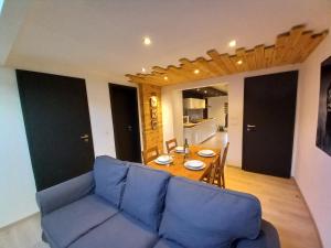 a living room with a blue couch and a table at Entre Nature Et Circuit in Francorchamps