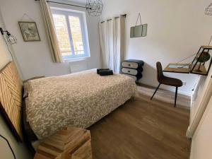 ein Schlafzimmer mit einem Bett und einem Stuhl und einem Fenster in der Unterkunft BALCON SUR LE MONDE - T2 COEUR DE VILLE in Agen