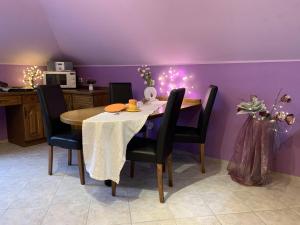 ein Esszimmer mit einem Tisch und einer lila Wand in der Unterkunft 2 - Zimmer Wohnung in Hilter am Teutoburger Wald