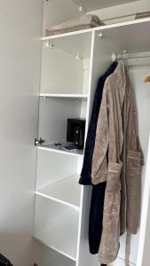 a closet with white shelves and a coat hanging at The Square Luxury Duplex Apartment in Springfield