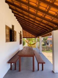 einem Holztisch und Bänken unter einer Holzdecke in der Unterkunft White House-Kite AliCori , Macapa' in Luis Correia