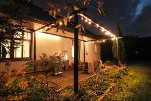 a pergola with lights on a house at night at Villa 124 SPA & Sauna komfortowy apartament Beskidy in Bystra