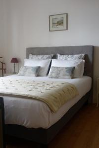 a bedroom with a large bed with white sheets and pillows at Bois de Cadène in Saint-Pierre-de-Buzet