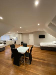 Habitación con mesa, sillas y cama en Buckingham Apartments, en High Wycombe