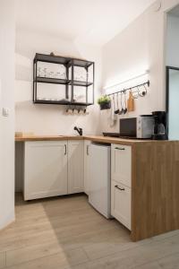 cocina con armarios blancos y encimera de madera en APARTMENT SAPICA, en Solkan