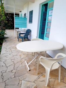 塔坦的住宿－DISTILLERIE，石头庭院里的白色桌子和椅子
