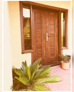 a wooden door of a house with two potted plants at Full Serviced Cottage in Bhurban in Ausia