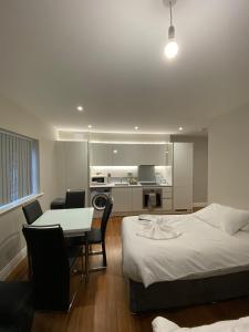 a bedroom with a bed and a table and a kitchen at Buckingham Apartments in High Wycombe